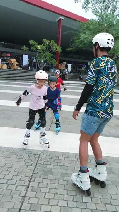 pelatih sepatu roda mengajarkan bermain sepatu roda ke tiga orang murid